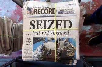 Stack of newspapers featuring a headline about the seizure of the Marion County Record, with images of a raid and the caption "SEIZED ... but not silenced."