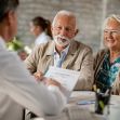 An older couple discussing healthcare options with a doctor in an office setting. An older couple discussing healthcare options with a doctor in an office setting.