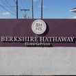 Sign for Berkshire Hathaway HomeServices with a purple and white design, featuring the company's logo. Sign for Berkshire Hathaway HomeServices with a purple and white design, featuring the company's logo.