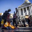 Protesters burning an American flag during a demonstration in front of a governmental building. Protesters burning an American flag during a demonstration in front of a governmental building.
