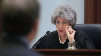 A judge addressing a case in a courtroom setting, emphasizing legal points during a hearing.