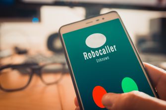 Image of a smartphone displaying an incoming call from a "Robocaller" identified as "Unknown" with options to accept or decline the call.