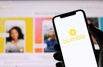 A person holding a smartphone displaying the Bumble logo, with the Bumble app interface in the background.