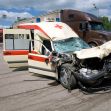 Damaged ambulance involved in a serious accident on a highway, with trucks in the background. Damaged ambulance involved in a serious accident on a highway, with trucks in the background.