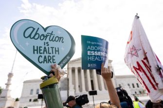 Protesters hold signs supporting abortion rights outside the U.S. Supreme Court.