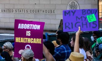 A crowd of protesters holding signs advocating for abortion rights outside the United States Courthouse.