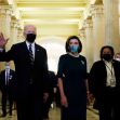 President Biden and Speaker Nancy Pelosi walking through a corridor, both wearing masks. President Biden and Speaker Nancy Pelosi walking through a corridor, both wearing masks.