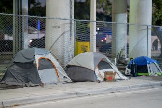 Tents set up in a urban area, highlighting the presence of homelessness.