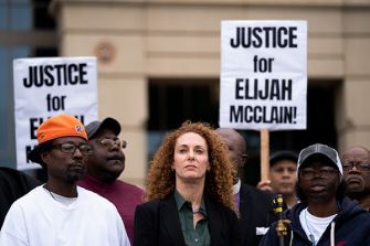Protesters holding signs advocating for justice for Elijah McClain during a demonstration in Aurora, Colorado.