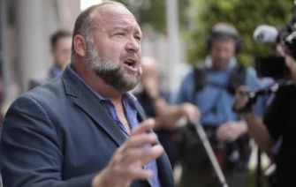 A man speaking passionately in front of a group of media personnel.
