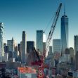 A view of a New York City skyline featuring construction cranes and skyscrapers. A view of a New York City skyline featuring construction cranes and skyscrapers.