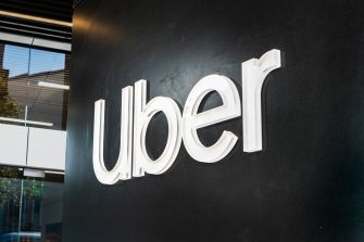 Uber logo displayed on a black wall at one of the company's locations.
