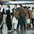 Group of Afghan evacuees arriving at an airport, wearing masks and being escorted through the terminal. Group of Afghan evacuees arriving at an airport, wearing masks and being escorted through the terminal.