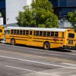 Yellow school buses parked along a street outside a school building. Yellow school buses parked along a street outside a school building.