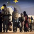 A line of migrants walking in a desert landscape, partially obscured by a waving European Union flag. A line of migrants walking in a desert landscape, partially obscured by a waving European Union flag.
