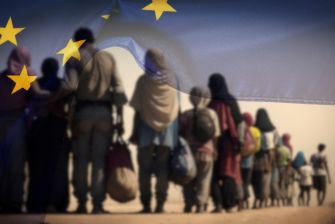 A line of migrants walking in a desert landscape, partially obscured by a waving European Union flag.