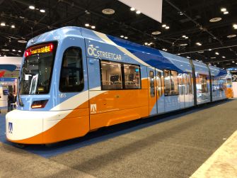 A brightly colored OC Streetcar model displayed at a transit show.