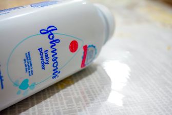 A container of Johnson's Baby Powder on a surface, highlighting its branding.