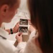 A couple holding an ultrasound image, symbolizing their journey through surrogacy. A couple holding an ultrasound image, symbolizing their journey through surrogacy.