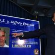 A man points at a poster detailing the case against Jeffrey Epstein, which includes his photo and a call to action for victims to contact the FBI. A man points at a poster detailing the case against Jeffrey Epstein, which includes his photo and a call to action for victims to contact the FBI.