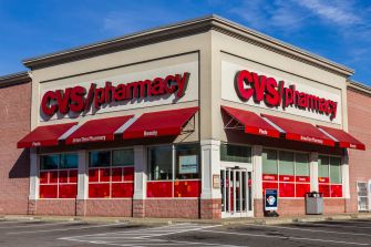 CVS pharmacy storefront with red signage and awnings under a blue sky.
