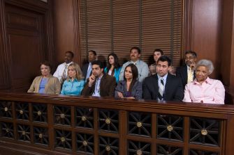 A diverse jury seated in a courtroom, observing a trial.