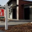 A "For Sale" sign in front of a house, indicating it's available for sale. A "For Sale" sign in front of a house, indicating it's available for sale.
