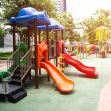 Playground equipment at a daycare facility, with slides and climbing structures surrounded by greenery. Playground equipment at a daycare facility, with slides and climbing structures surrounded by greenery.