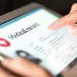 Close-up of a person's hand using a tablet to view a medical record. Close-up of a person's hand using a tablet to view a medical record.