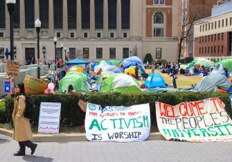 Tents and protest signs set up on a university campus during a pro-Palestinian protest.
