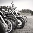 Row of motorcycles parked outdoors, showing the front tires and detailing. Row of motorcycles parked outdoors, showing the front tires and detailing.