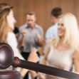 A gavel in the foreground with a blurred background of people socializing, symbolizing changes in the legal system. A gavel in the foreground with a blurred background of people socializing, symbolizing changes in the legal system.