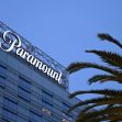 Paramount's office building with the company logo illuminated at night, surrounded by palm trees. Paramount's office building with the company logo illuminated at night, surrounded by palm trees.