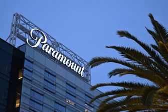 Paramount's office building with the company logo illuminated at night, surrounded by palm trees.