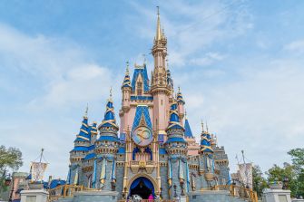 A close-up view of Cinderella Castle at Disneyland, showcasing its intricate architecture and vibrant colors against a blue sky.