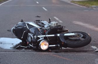 A motorcycle lying on its side on the road after a crash.