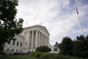 Exterior view of the U.S. Supreme Court building, featuring its iconic columns and a flagpole.