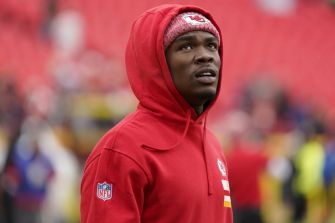 Kansas City Chiefs wide receiver Rashee Rice in a red hoodie during warm-ups at a stadium.