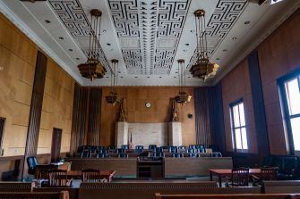 A courtroom with wooden benches and a decorative ceiling, depicting a formal setting for legal proceedings.