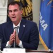 Governor Kevin Stitt of Oklahoma speaking during a meeting, with state flags in the background. Governor Kevin Stitt of Oklahoma speaking during a meeting, with state flags in the background.