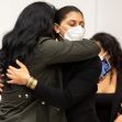 Two women embrace in a courtroom setting, celebrating after a verdict in a case involving press freedom. Two women embrace in a courtroom setting, celebrating after a verdict in a case involving press freedom.