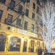 Exterior view of Mamajuana Cafe, a restaurant located in New York City, adorned with holiday lights. Exterior view of Mamajuana Cafe, a restaurant located in New York City, adorned with holiday lights.