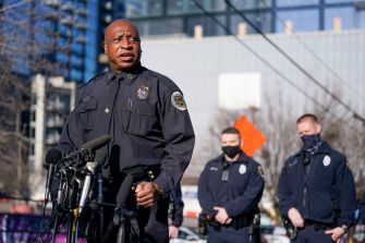 A police official speaking at a press conference regarding the Nashville bombing investigation, with other officers in attendance.
