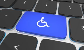 A blue key on a computer keyboard featuring a wheelchair symbol, representing accessibility for individuals with disabilities.