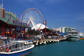 View of Navy Pier in Chicago, featuring the waterfront, the iconic Ferris wheel, and recreational boats.