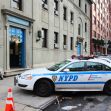 Image of an NYPD police car parked outside a police station on a city street. Image of an NYPD police car parked outside a police station on a city street.