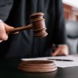 A judge's gavel being brought down in a courtroom setting. A judge's gavel being brought down in a courtroom setting.