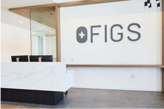 Modern office reception area with the Figs logo prominently displayed.