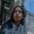 A young woman looking thoughtfully out a window, reflecting on her experiences and challenges in education. A young woman looking thoughtfully out a window, reflecting on her experiences and challenges in education.