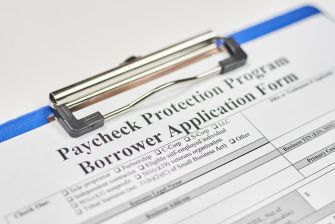 Paycheck Protection Program borrower application form on a clipboard.